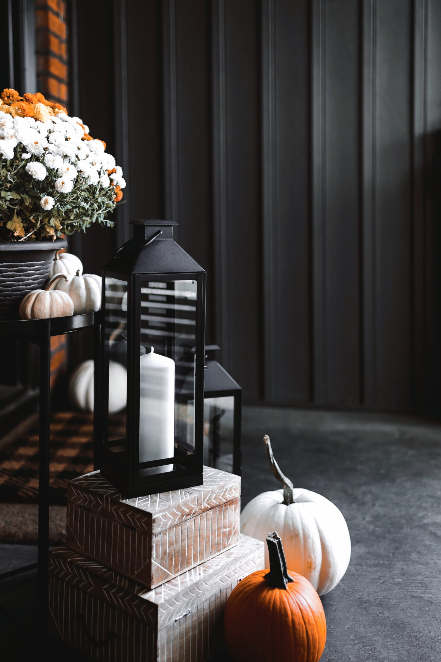 Fall decor scene with pumpkins, flowers, and candles