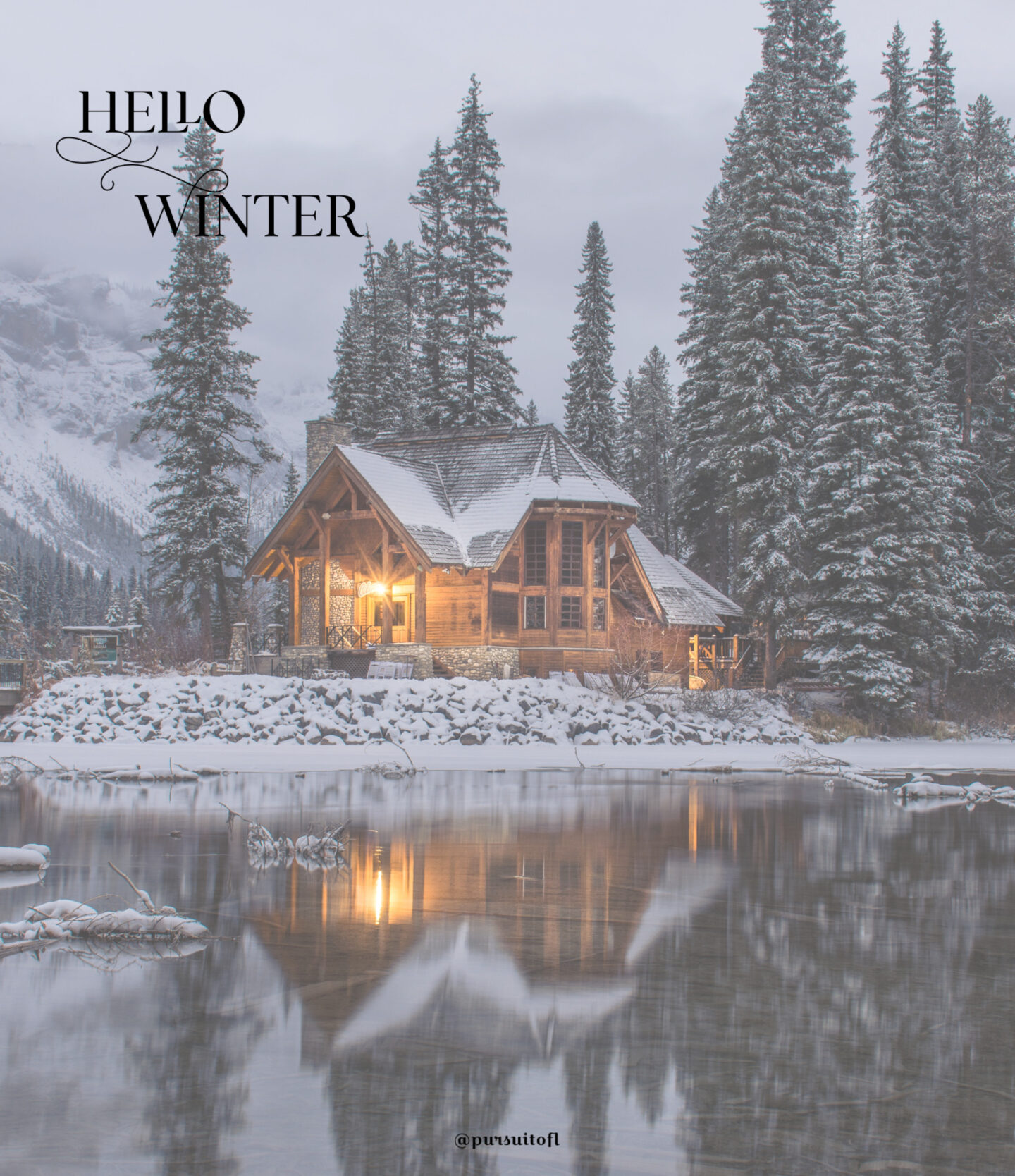 Winter tablet wallpaper with log cabin on a lake in a snowy forest with hello winter text
